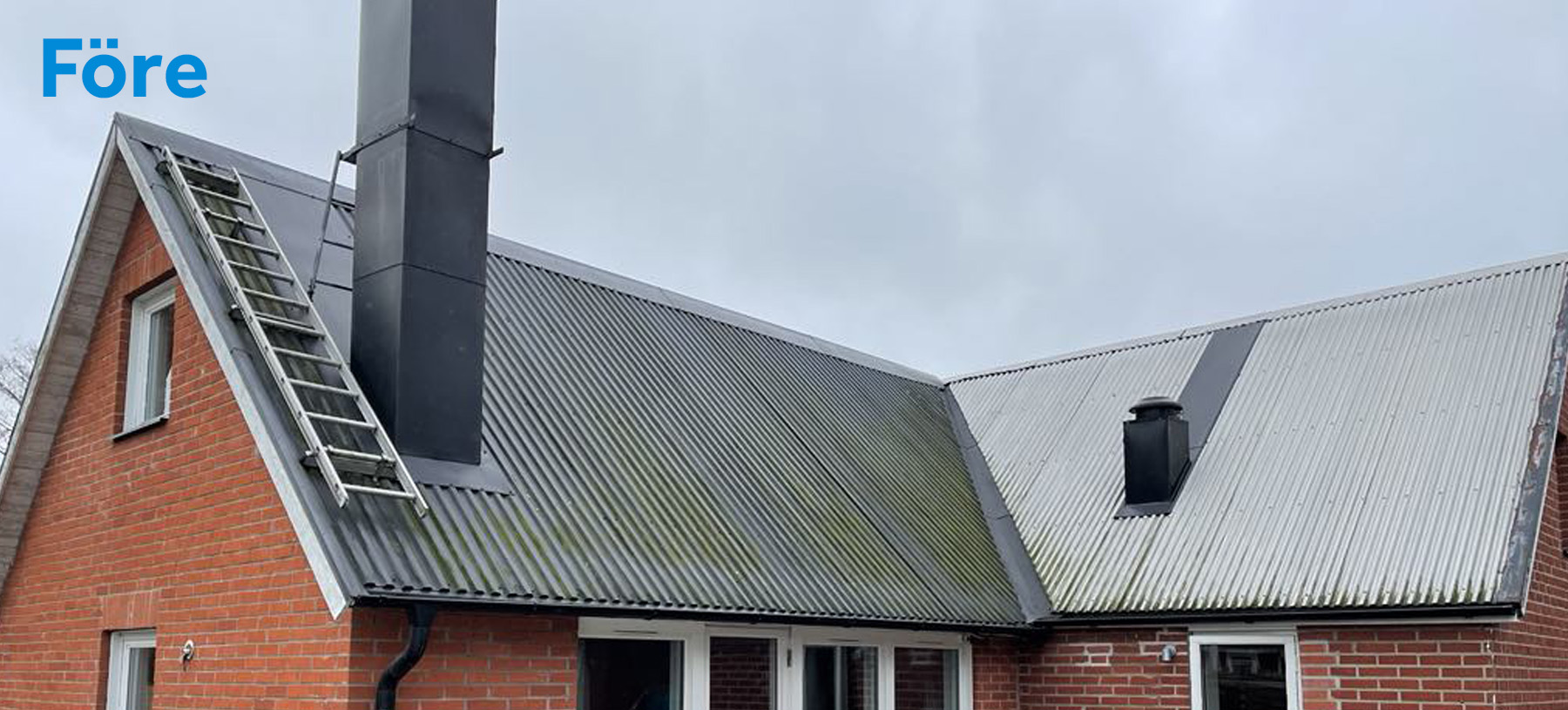 Hus före svart listtäckning och vit puts (plåttak och tegelfasad)