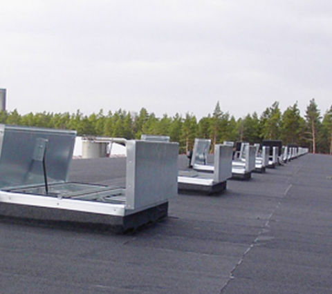 Låglutande tak med många brandgasventilatorer på en rad.