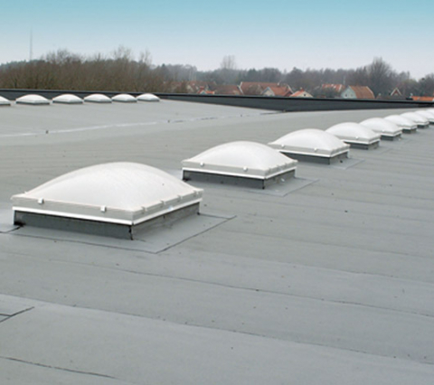 Låglutande tak med många takljuskupoler på en rad.